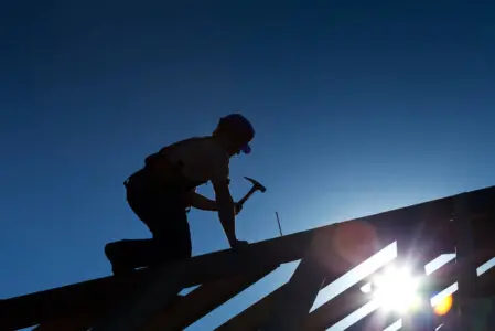 Charpentier travaillant sur une charpente en bois sur une maison